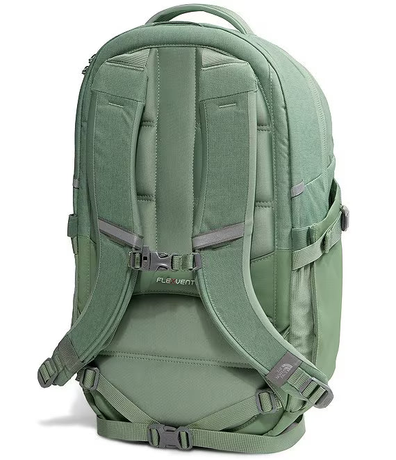 The back view of a sage green The North Face backpack, showing the padded shoulder straps, ventilation channels, and adjustable buckled straps on a white background.