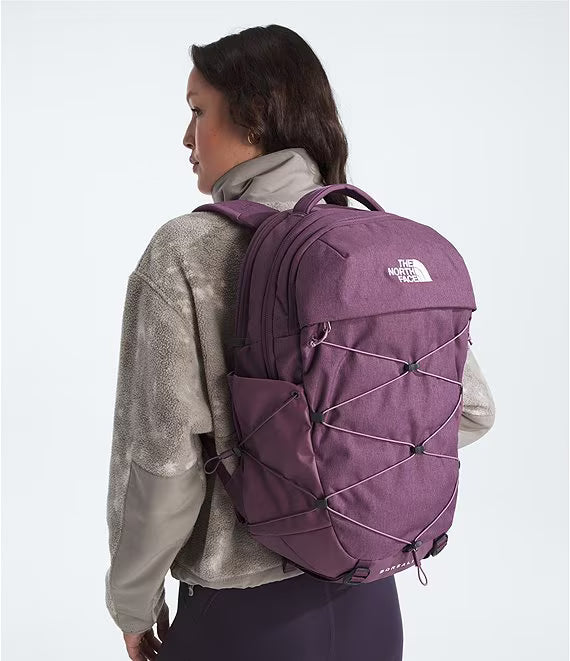 Person wearing a purple backpack with The North Face logo on a white background