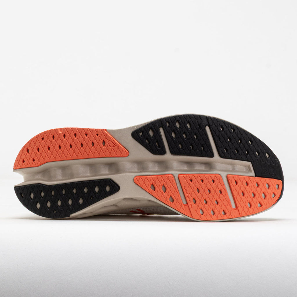 Close-up of a running shoe sole with orange and black pattern on a white background