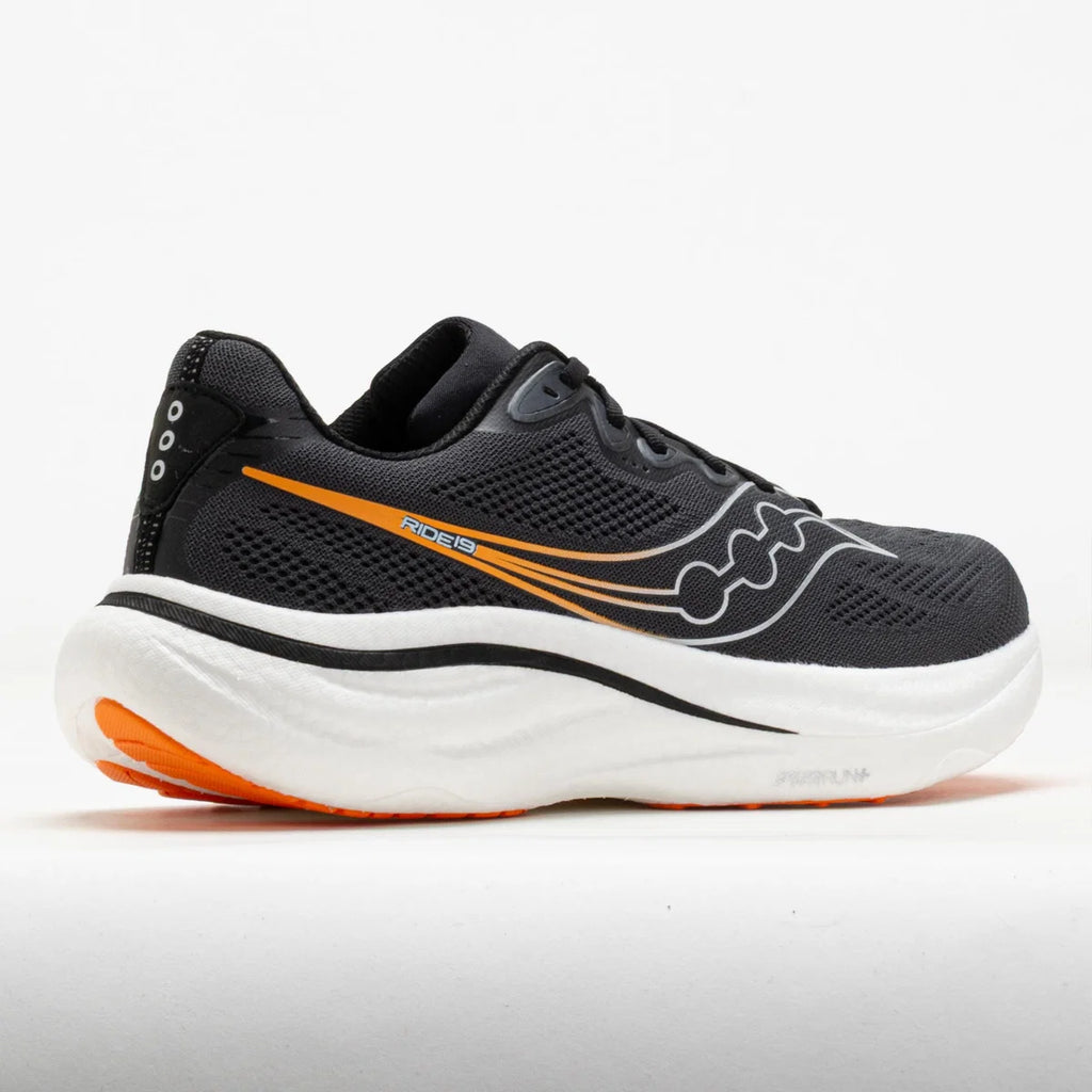 A Saucony running shoe in black mesh with a thick white midsole and bright orange accents on the side and outsole, shown against a plain white background.