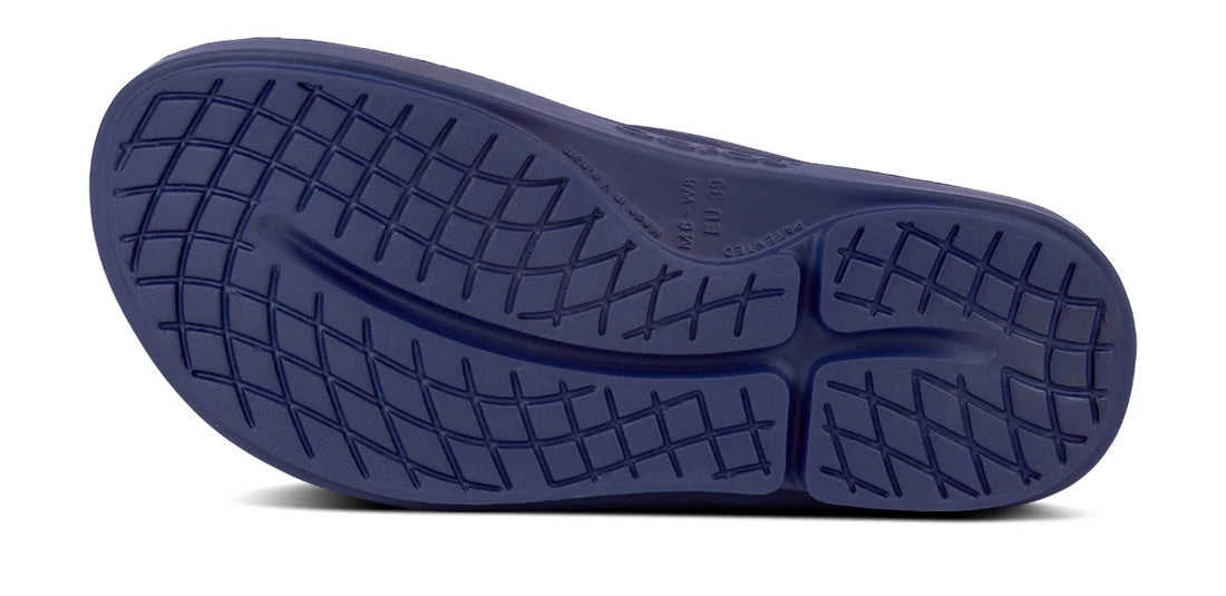 A close-up of a dark navy blue shoe sole with a textured grid tread pattern, shown against a plain white background.