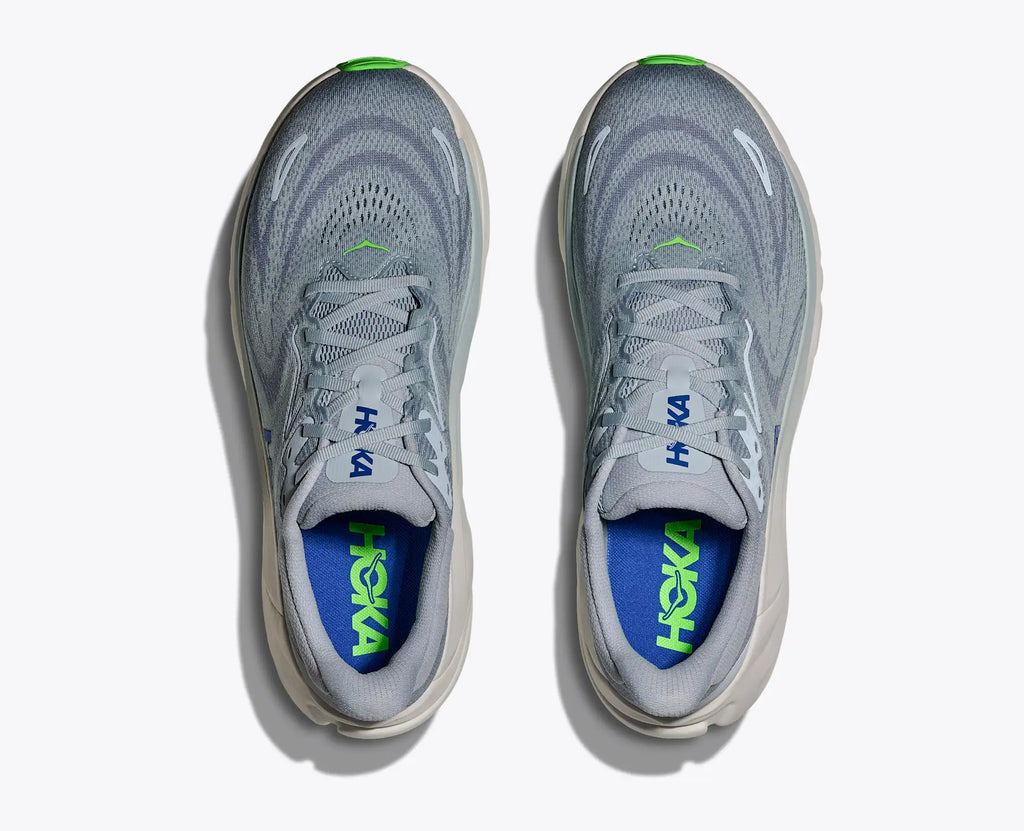 Gray running shoes with blue and green sole on a white background