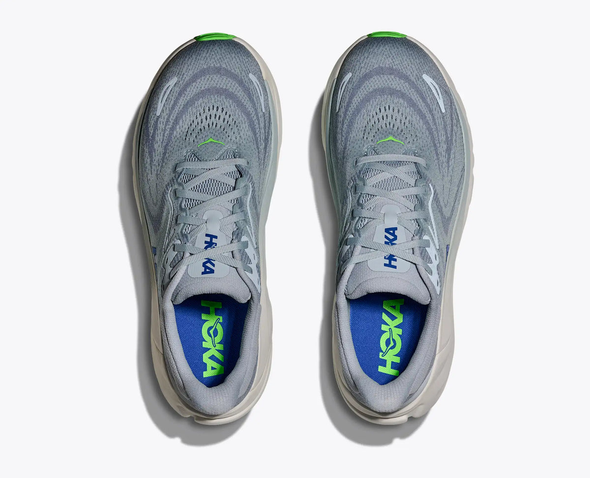 Gray running shoes with blue and green sole on a white background