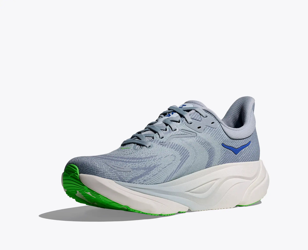 Gray running shoe with green sole on a white background