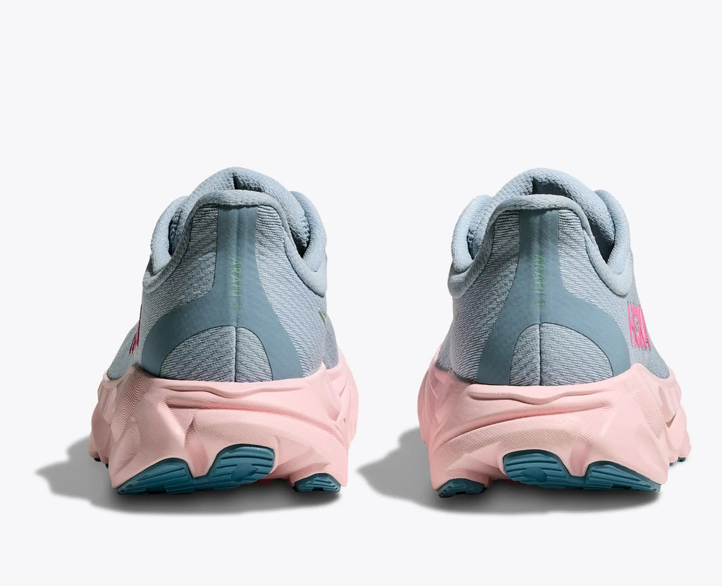 Pair of gray and pink running shoes with blue soles on a white background