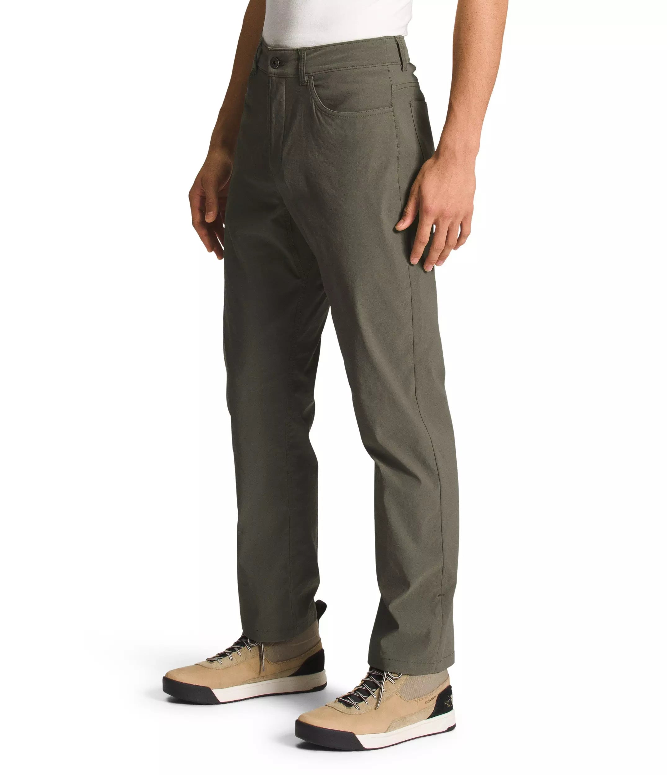 A person wearing olive green straight-leg work pants with tan sneakers, shown from the waist down against a plain white background.