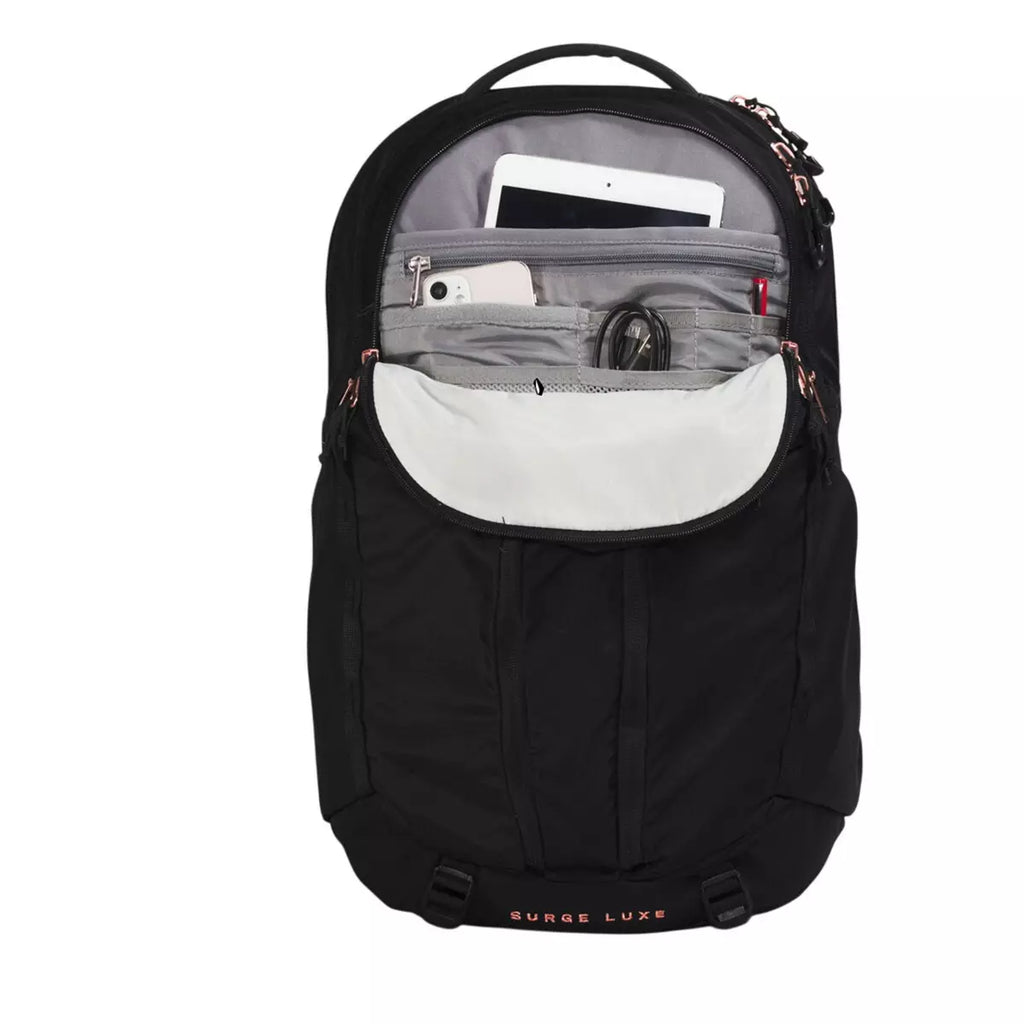 A black backpack shown from the front with its main compartment open, revealing gray interior pockets holding a tablet, phone, and cables. The brand name 'BURGE LUXE' is printed in rose gold on the lower front, and the backpack is photographed on a solid white background.