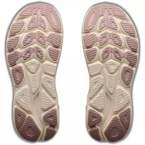 A pair of athletic shoes shown from the sole side, featuring a dual-tone design with a cream-colored midsole and dusty pink and mauve outsole tread patterns.