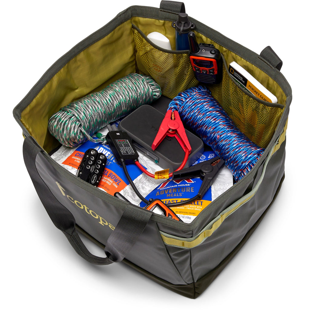An open Ecotape utility bag filled with fishing and outdoor gear, including a coiled green-and-white rope, a blue-and-white rope, a red clamp, a black device, and packaged accessories, shown on a white background.