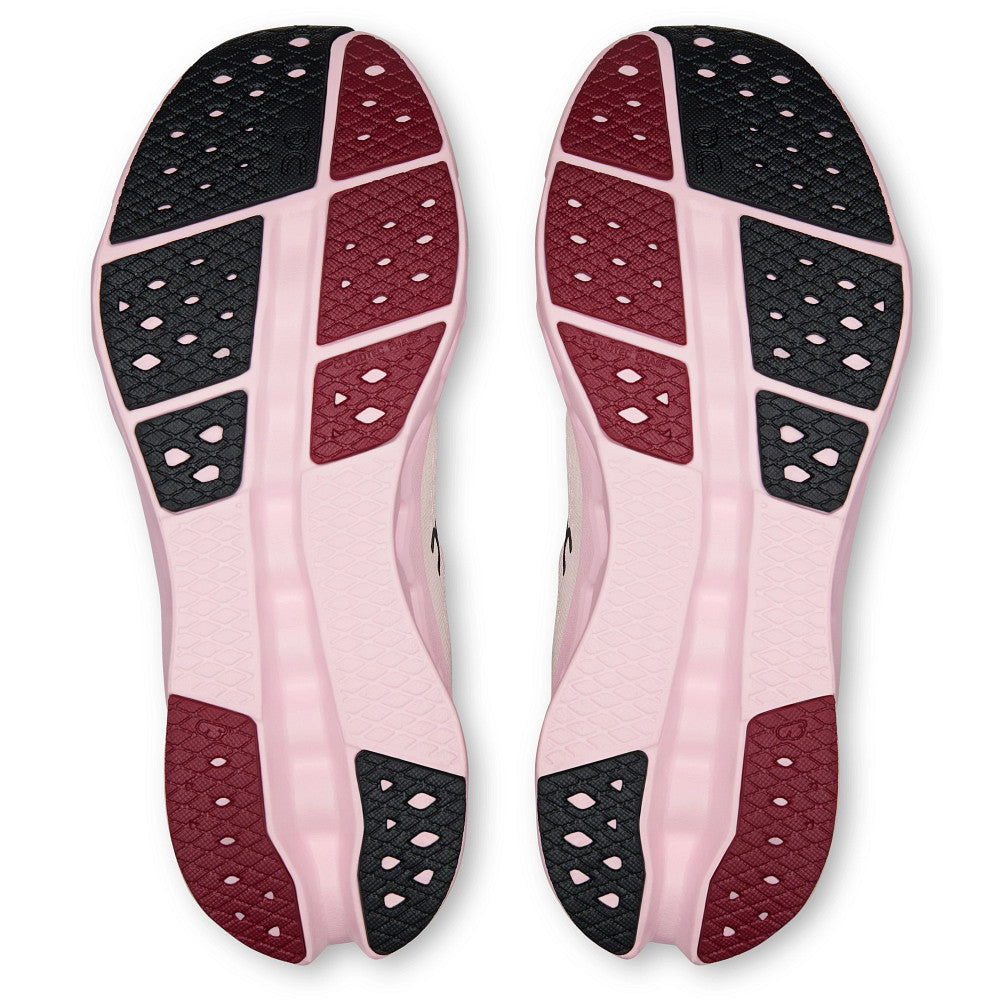 Pink insoles with black and red textured sole design on a white background
