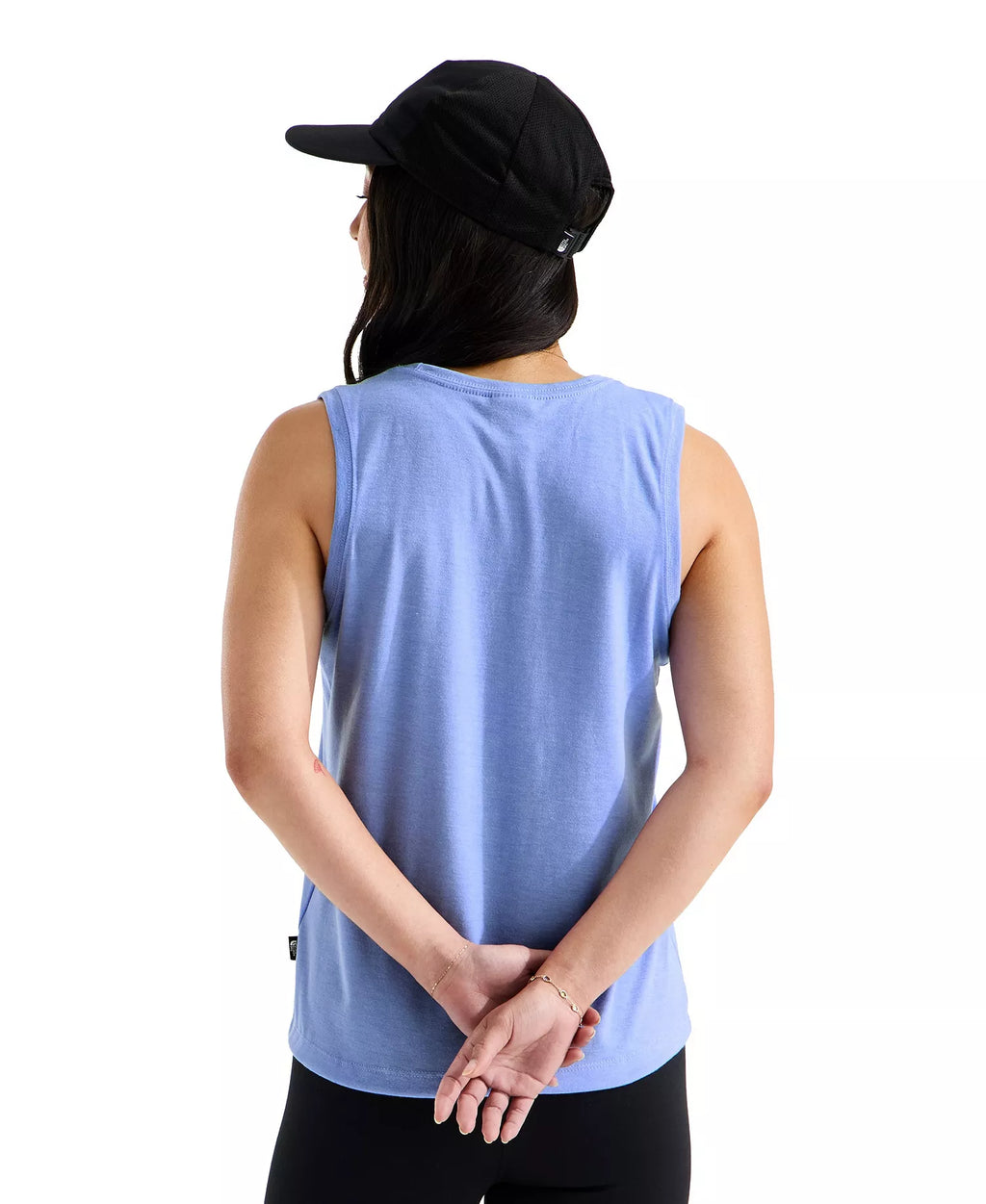 Person wearing a light blue sleeveless shirt and black cap on a white background