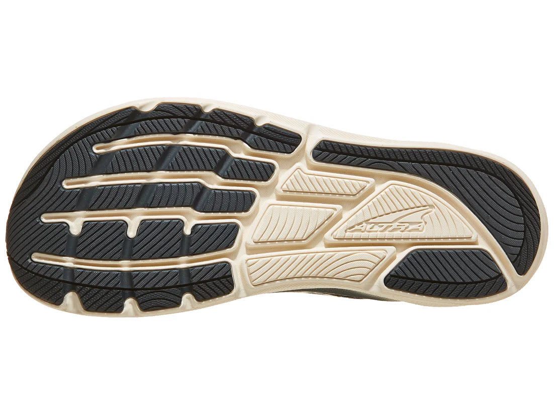 Close-up of a running shoe sole with black and beige pattern on a white background