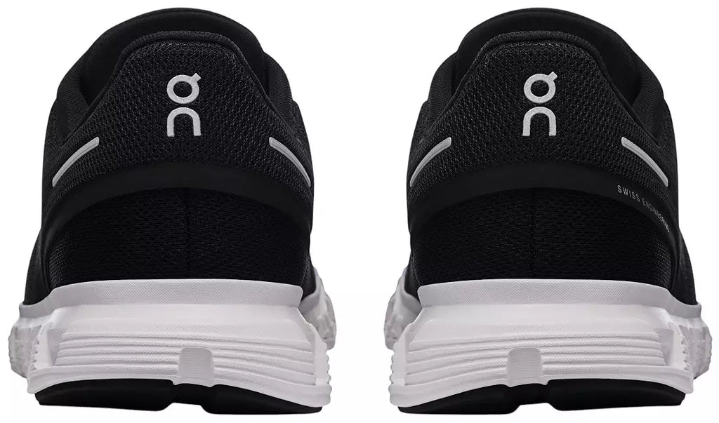 Black and white running shoes shown from the rear, featuring the white 'on' logo on the heel and a thick white cushioned sole.