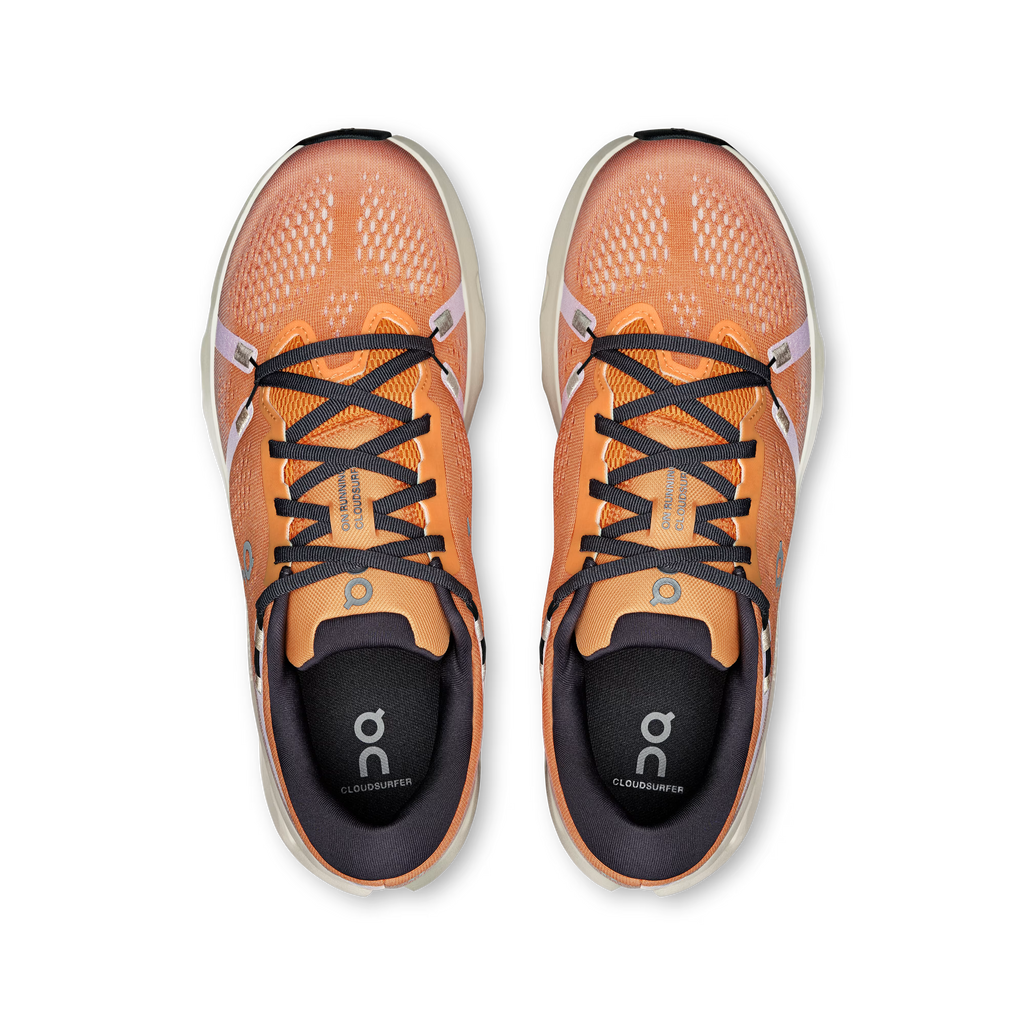 Pair of orange running shoes with black laces on a white background