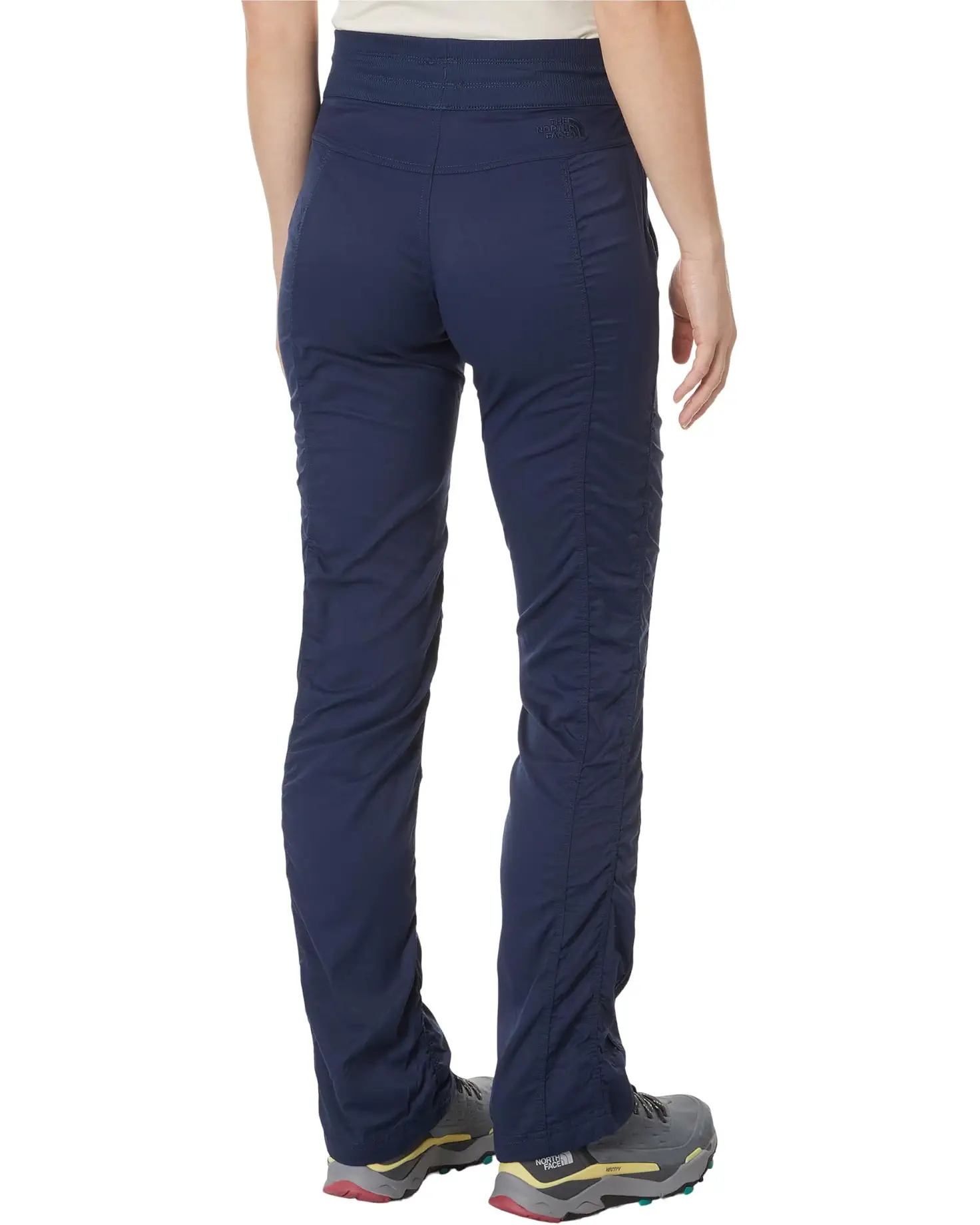 Navy blue pants worn by a person on a white background