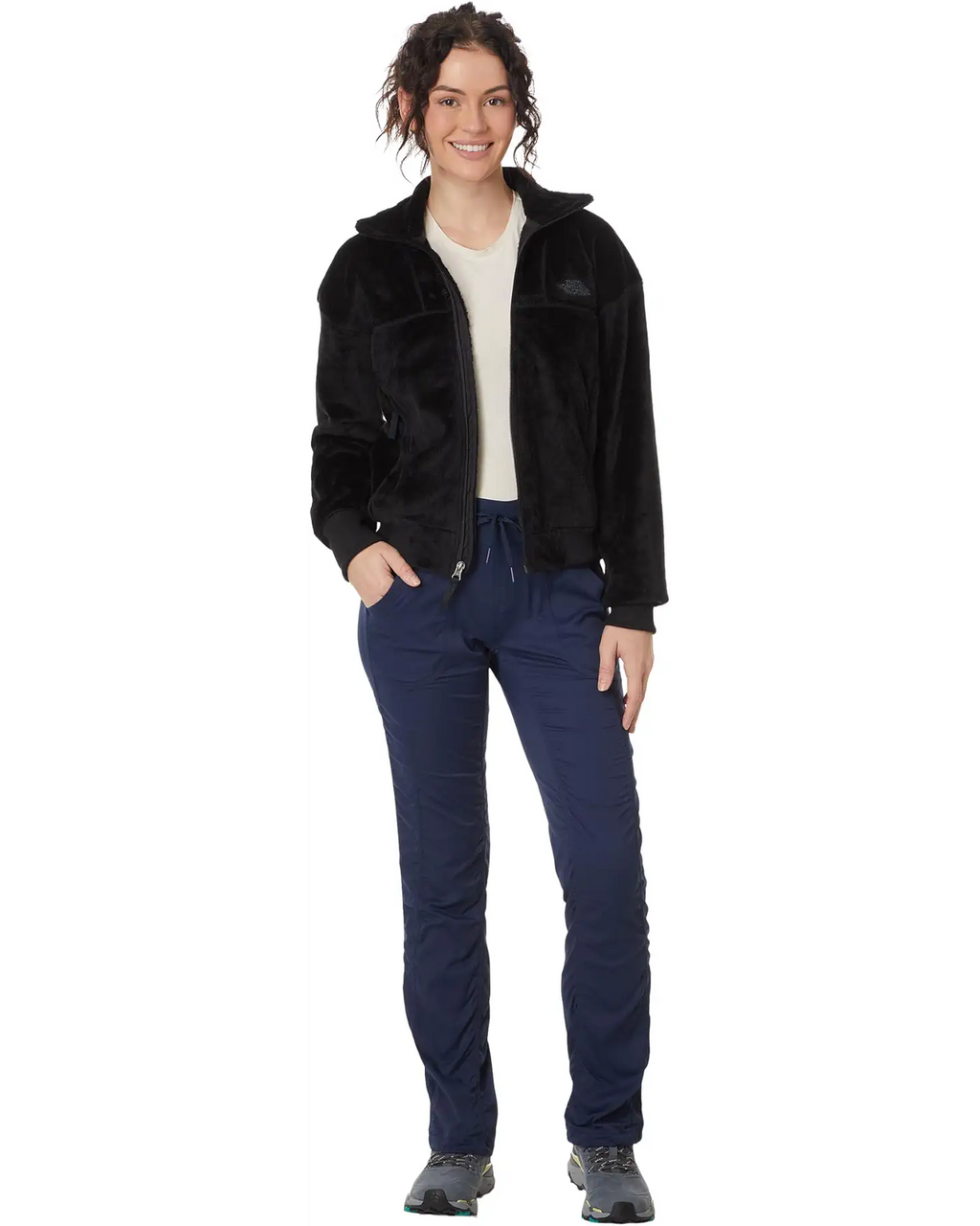 Person wearing a black jacket and blue pants on a white background
