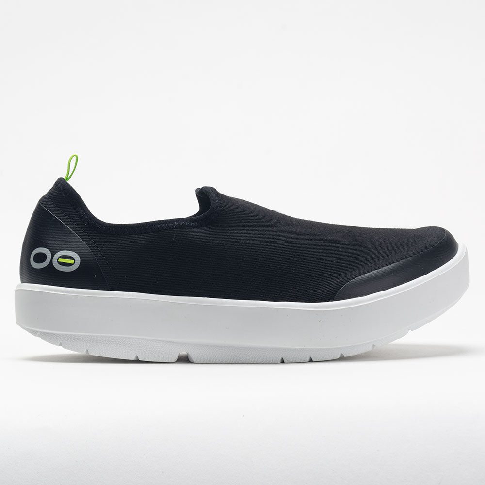 Black slip-on shoe with white sole on a light gray background