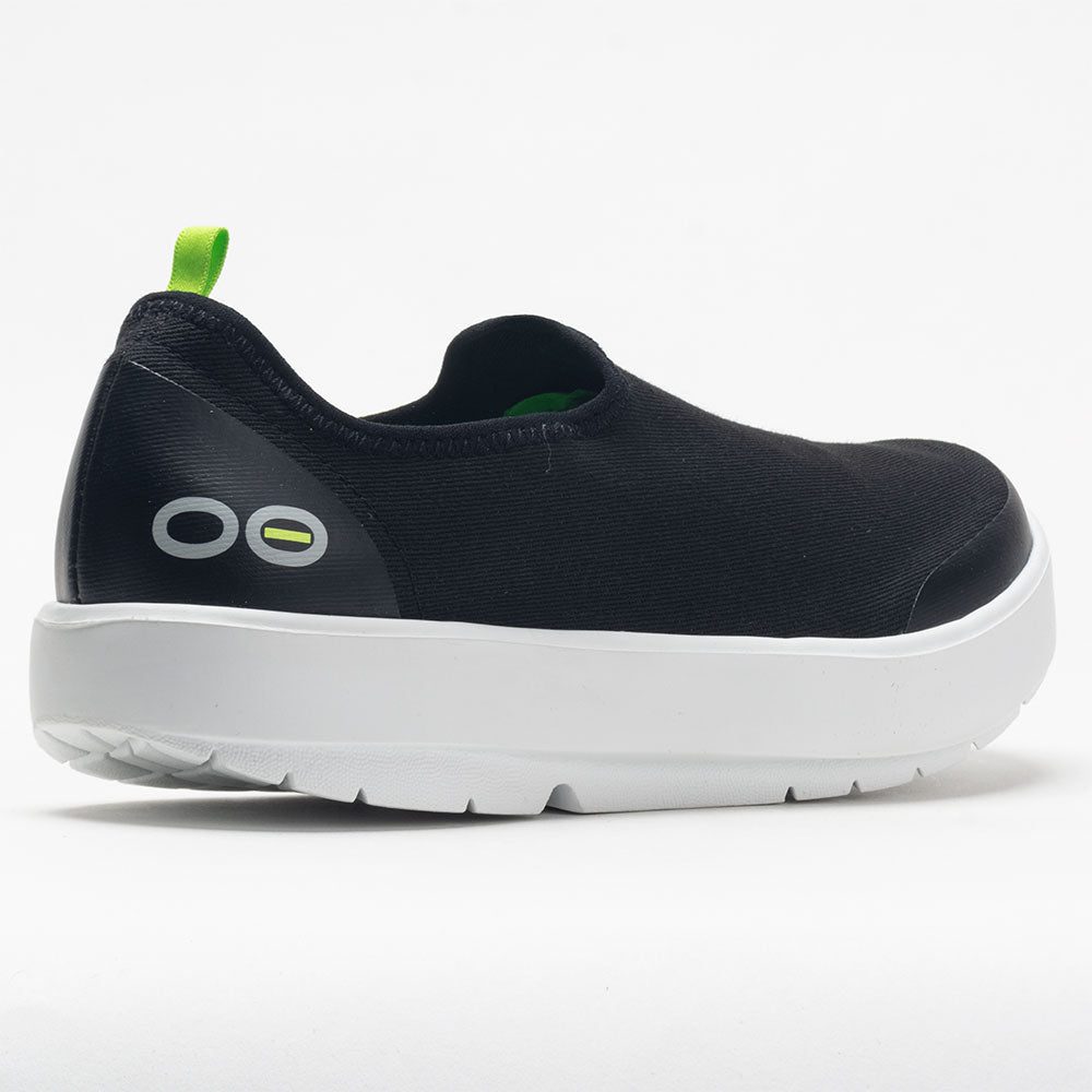 Black slip-on shoe with white sole on a white background