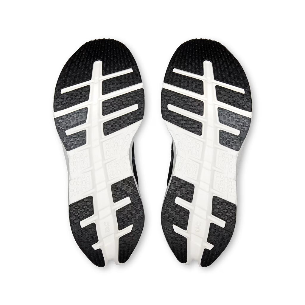 A pair of athletic shoes shown from the sole view, featuring a black and white treaded outsole with a grid-like pattern on a clean white background.