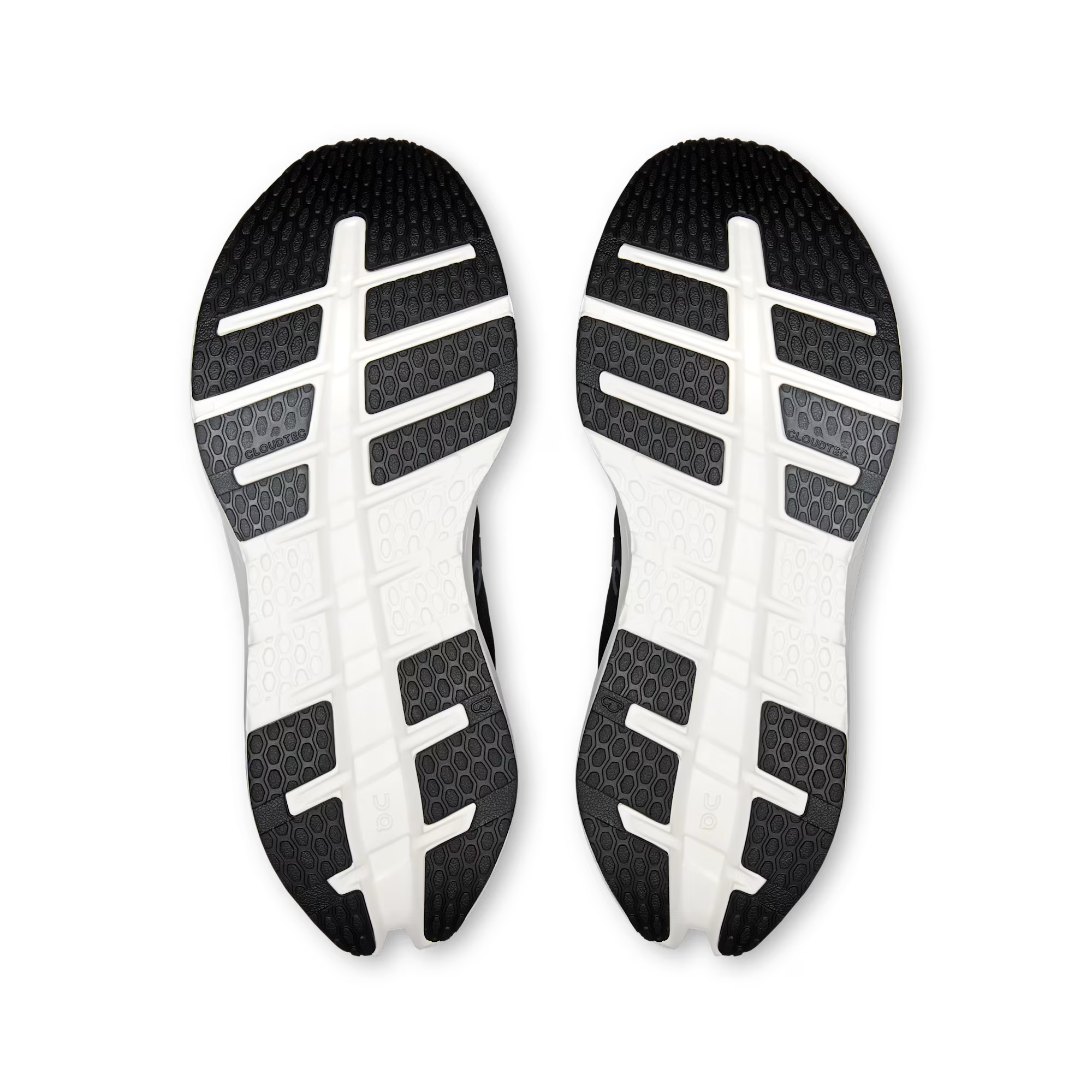 A pair of athletic shoes shown from the sole view, featuring a black and white treaded outsole with a grid-like pattern on a clean white background.