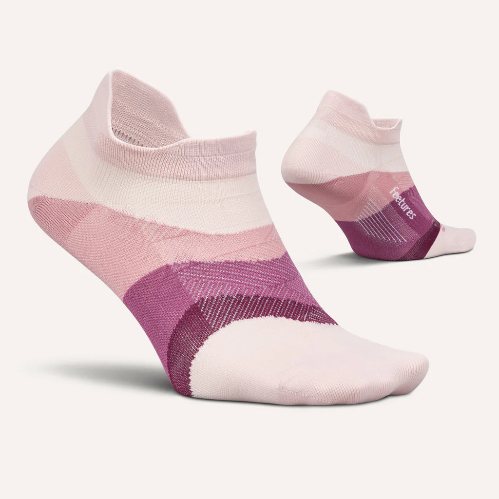 A pair of low-cut ankle socks in a soft pink and purple color-blocked pattern, shown on a light cream background with one sock in the foreground and the other showing the heel and toe from the side.