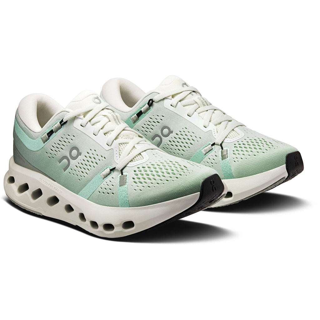 Pair of light green and white running shoes on a white background