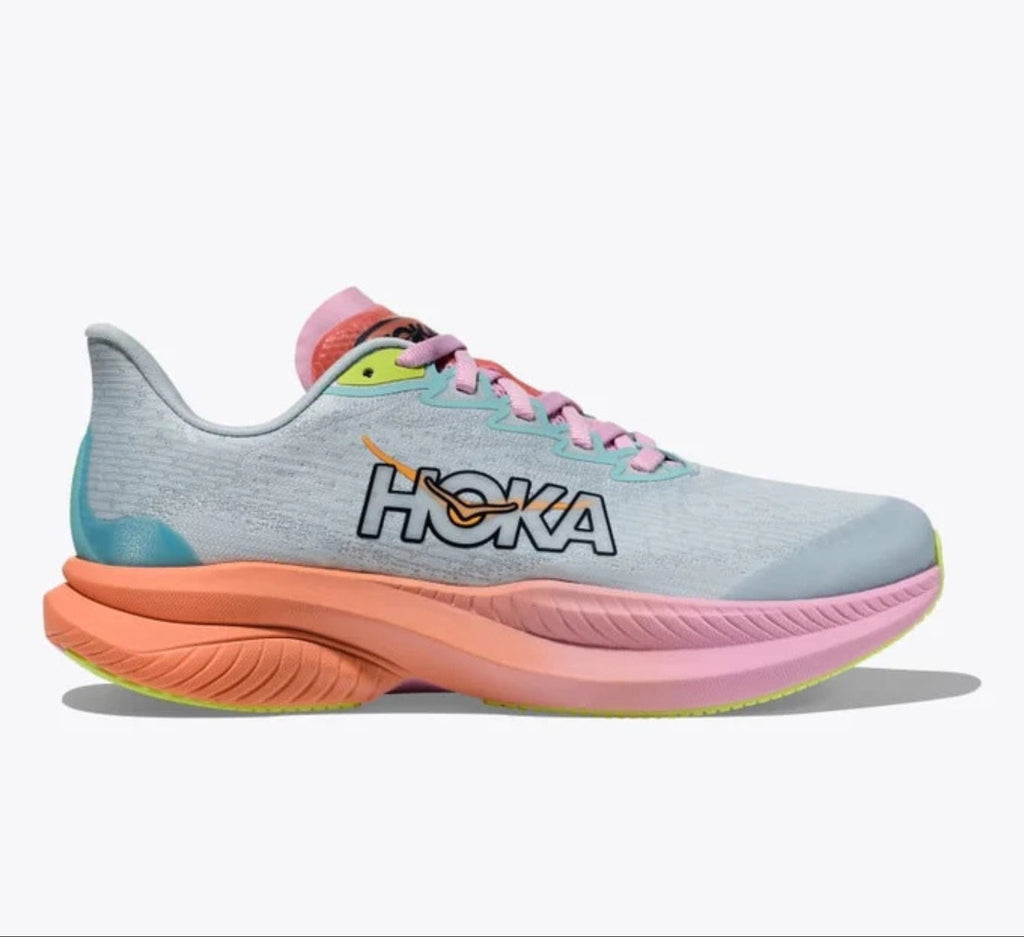A Hoka running shoe in light gray and pastel blue with a thick coral-pink and pink midsole, teal heel accent, and neon yellow-green outsole details, shown against a plain white background.