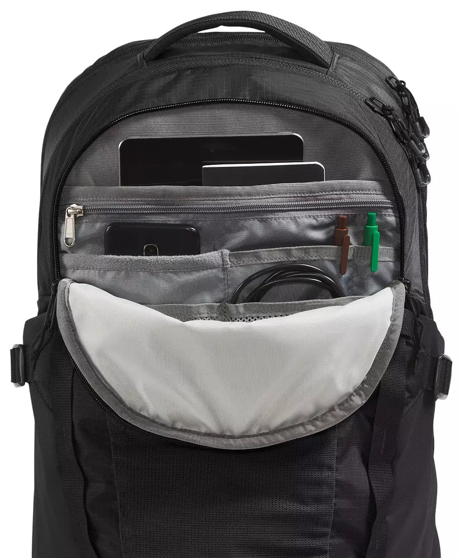A black and gray backpack shown open, displaying its interior compartments with a laptop, smartphone, pen, and cable inside, on a white background.