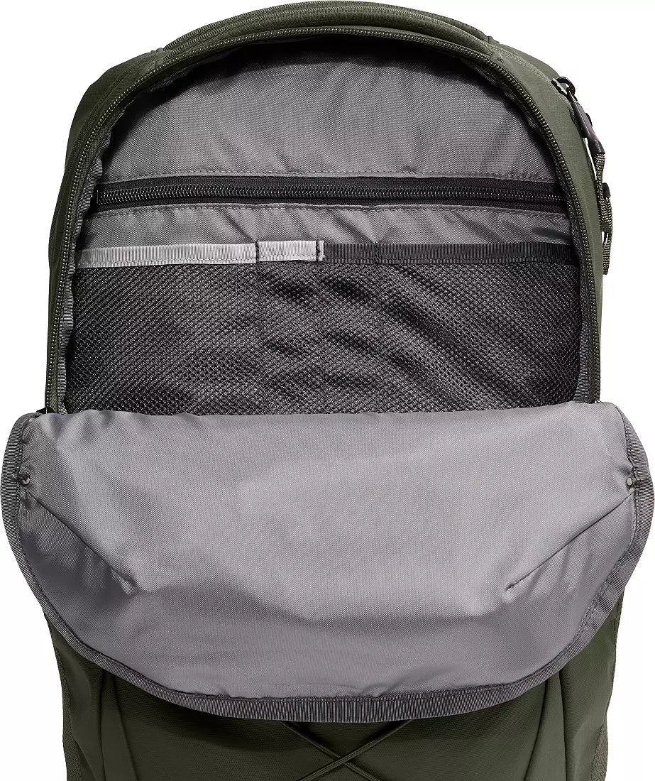 Close-up of the open front compartment of a backpack, showing a gray interior lining, mesh pocket, zipper compartment, and olive green exterior fabric.