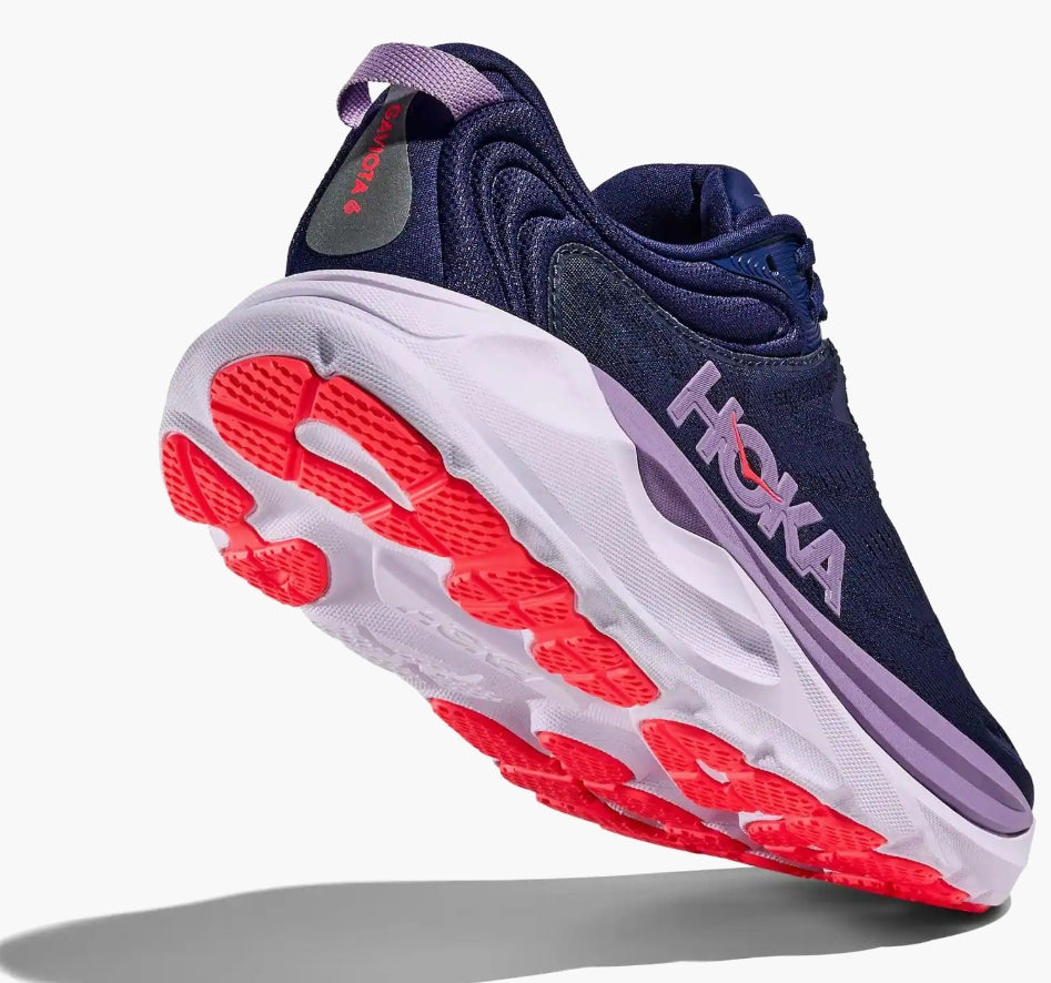 Navy running shoe with red sole on a white background