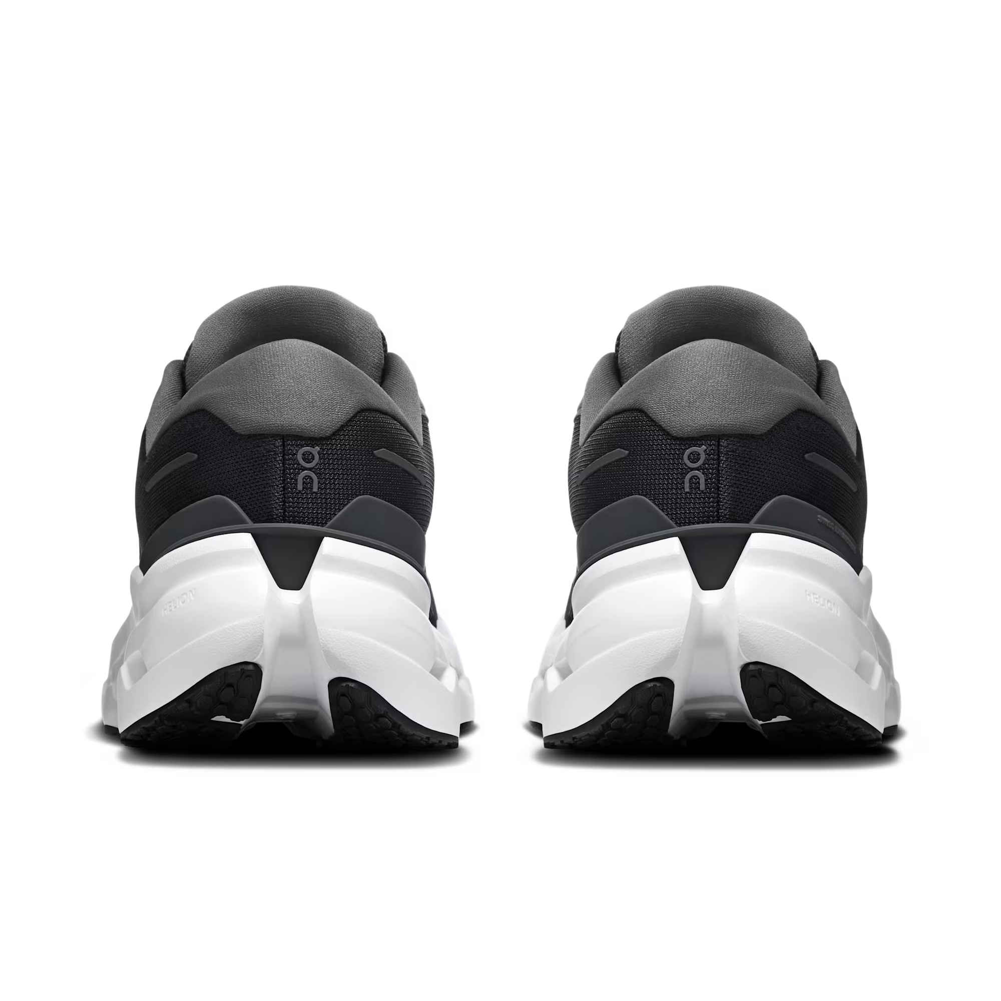 Rear view of a pair of athletic sneakers in black and dark gray with chunky white midsoles, shown on a clean white background.