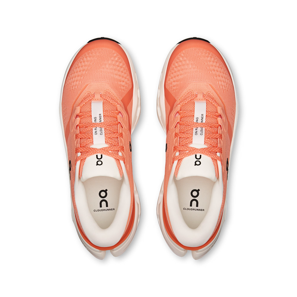 Pair of coral running shoes with white soles on a transparent background