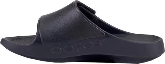 A single black Oofos slide sandal shown from a side profile view against a plain white background.