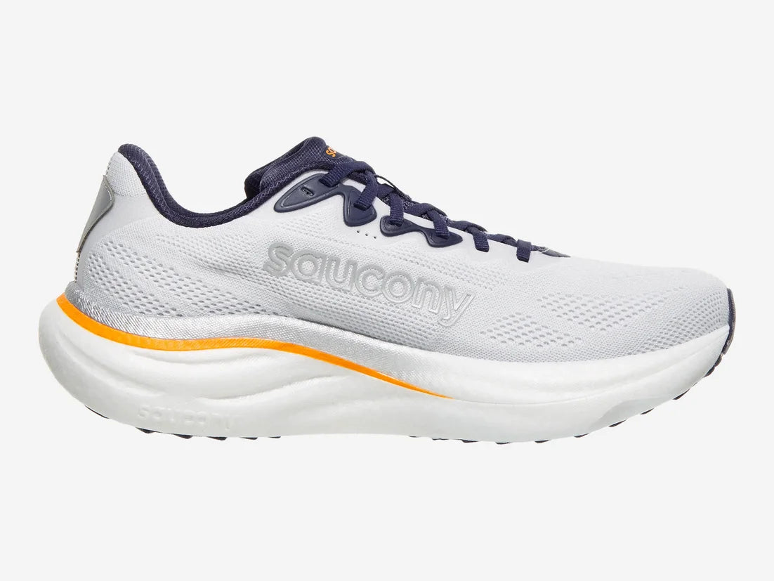 A Saucony running shoe in white with navy blue laces and collar lining, and a bright orange accent line on the midsole, shown against a light gray background.